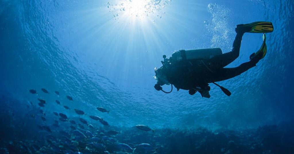 Beginner scuba diver exploring shallow coral reef during training