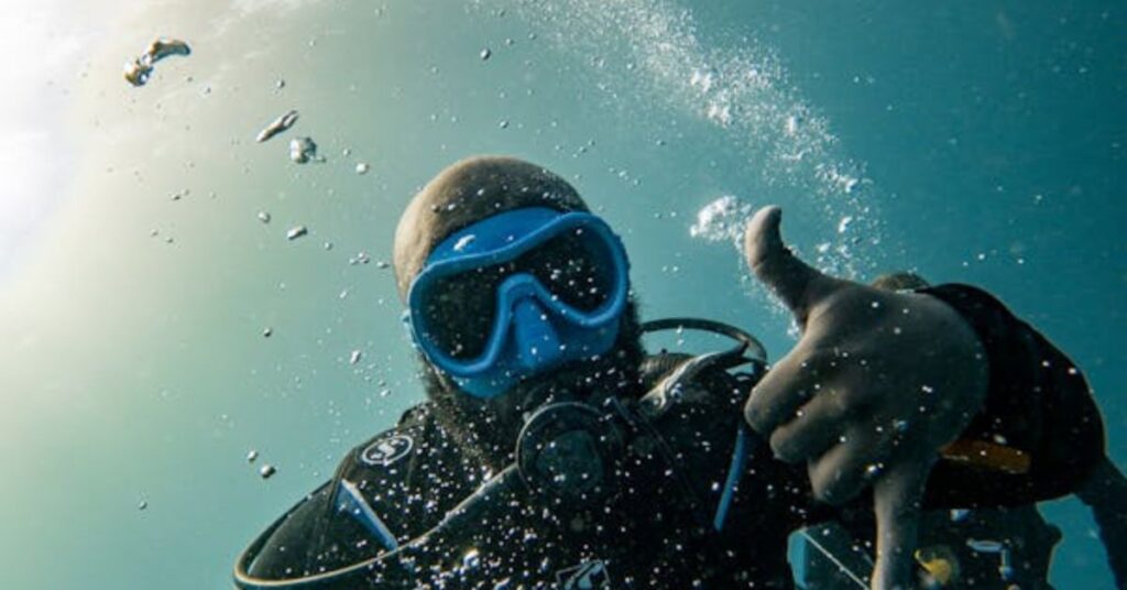 Diver showing the OK hand signal underwater
