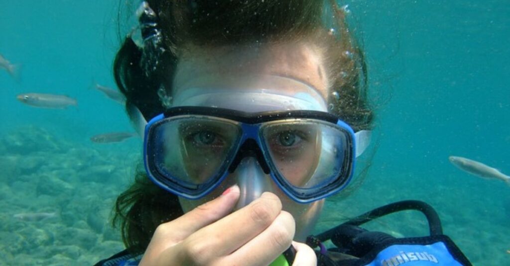 Scuba diver demonstrating how to clear a mask scuba diving underwater