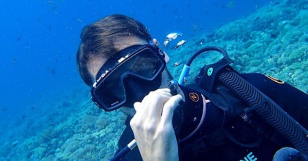 Diver struggling with mask flooding during scuba diving